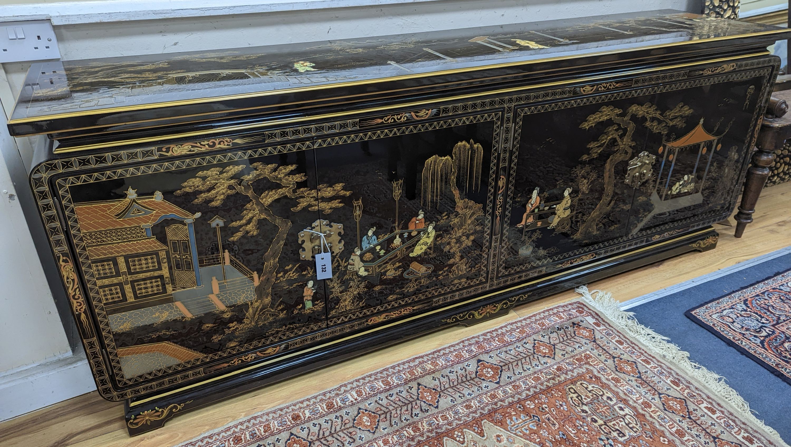 A Chinese lacquer decorated low cabinet. W-200cm, D-45cm, H-75cm.